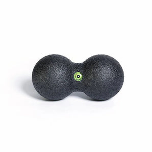 Black massage ball with a green dot on a white background