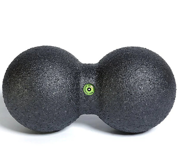 Black massage ball with a green dot on a white background