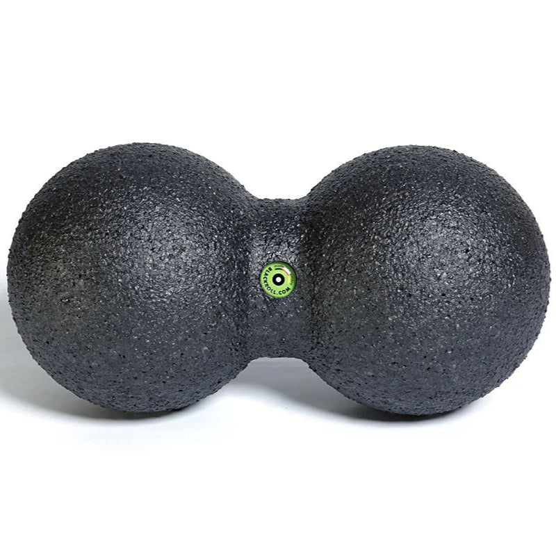 Black massage ball with a green dot on a white background