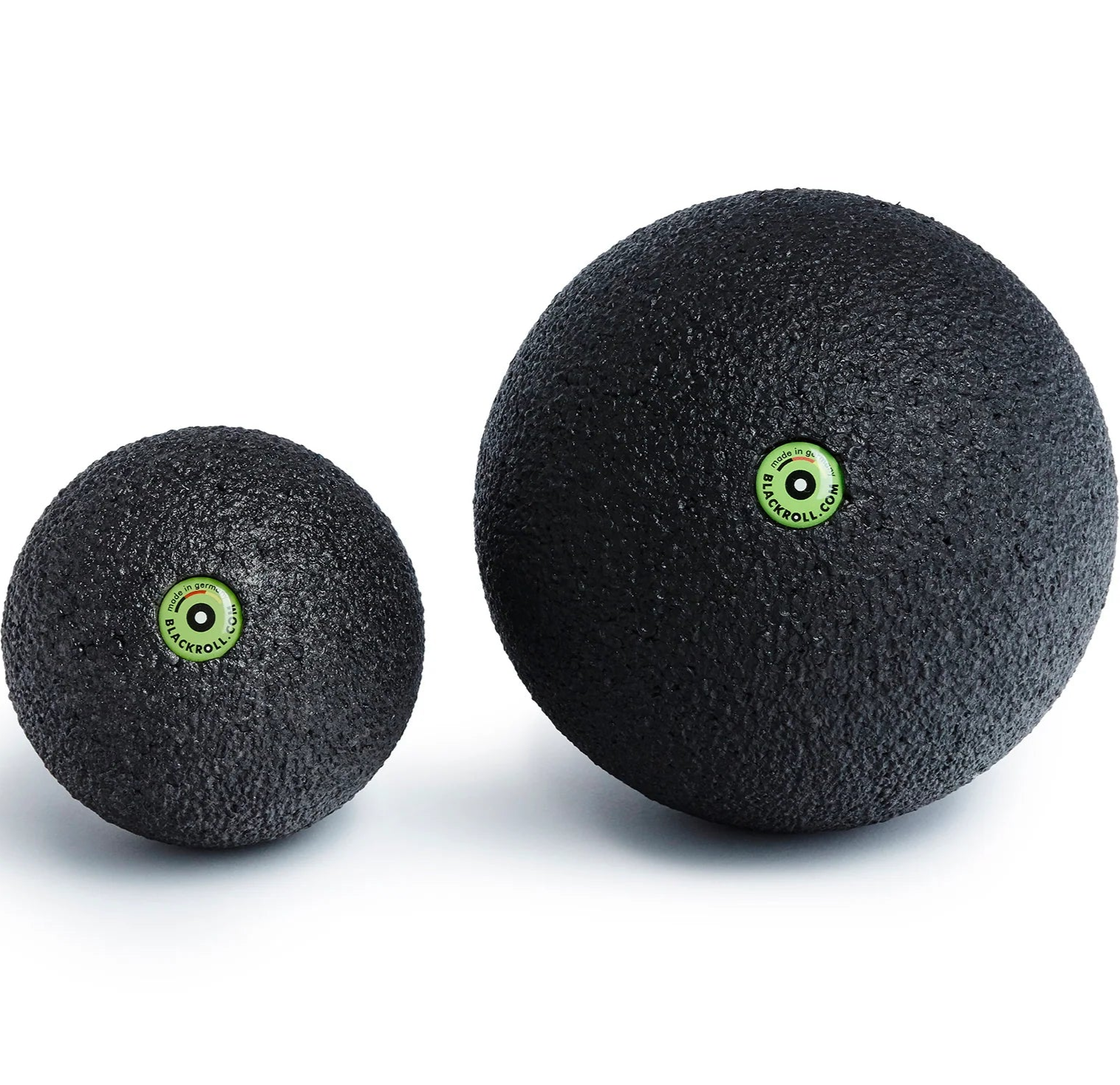 Two black massage balls with green logos on a white background