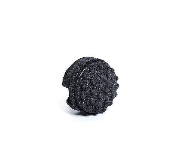 Black textured foam roller on a white background