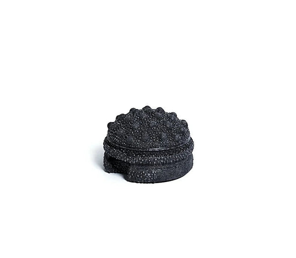 black textured massage ball on a white background