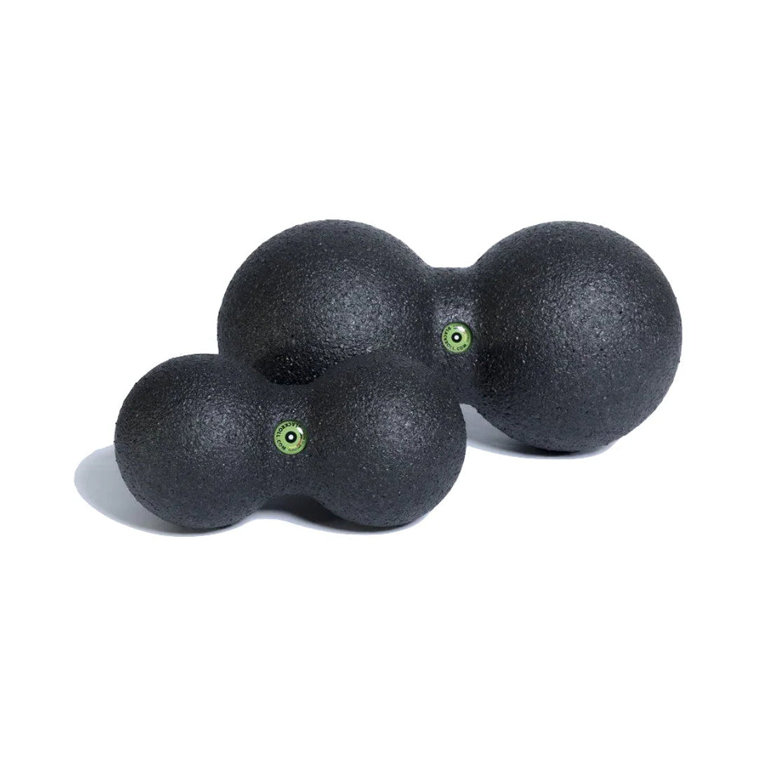 Two black massage balls with green accents on a white background